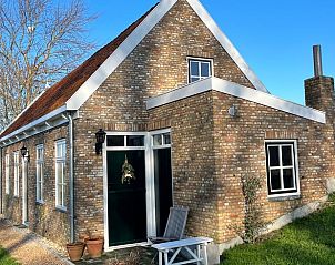 Charmant vakantiehuisje in Kamperland, Zeeland met bakstenen gevel en groene omgeving.