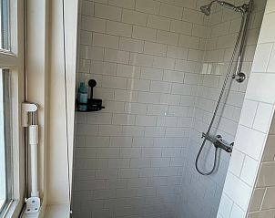 Douche in Vakantiehuisje in Kamperland met uitzicht op het groene landschap van Zeeland.