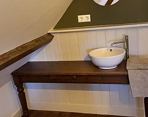 Bovenverdieping van Vakantiehuisje in Kamperland met houten wastafel en spiegel.