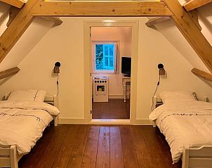 Kinderkamer in Vakantiehuisje in Kamperland met twee bedden en houten details.