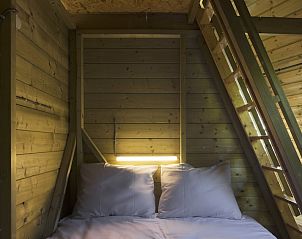 Attraktives Schlafzimmer mit Holzausstattung im Wigwam-Zelthaus Kamperland, ideal fr einen entspannten Aufenthalt in Noord-Beveland, Zeeland.