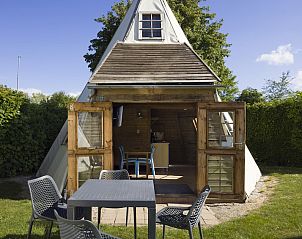 Vorderseite des Wigwam-Zelthauses in Kamperland mit einladender Terrasse und grnem Garten, einem einzigartigen Glamping-Erlebnis in Noord-Beveland, Zeeland.