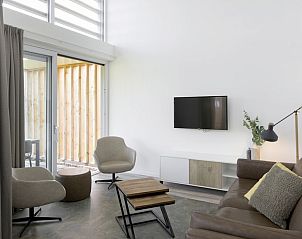 Moderne woonkamer in Bungalow 6B, Kamperland, Noord-Beveland, Zeeland, met comfortabele zitruimte en uitzicht op het terras.