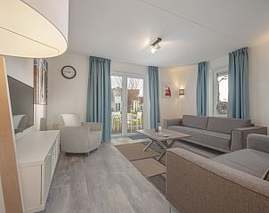 Gemtliches Wohnzimmer der Villa R5B in Kamperland, Noord-Beveland, Zeeland, mit bequemer Sitzecke und Gartenblick.