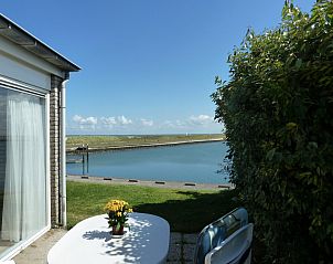 Terras aan het water bij Ostrea 25 | Roompot Beach Resort, vakantiehuis in Kamperland, met uitzicht op de dijk.