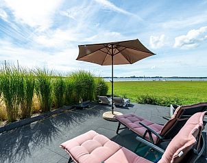 Buitenzitje van VZ2312 Vakantiehuis in Kamperland met uitzicht op het meer, Noord-Beveland, Zeeland.
