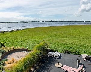Terras van VZ2312 Vakantiehuis in Kamperland met ligstoelen en uitzicht op het meer, Noord-Beveland, Zeeland.