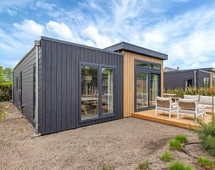 Chalet de Roerganger in Kamperland, Noord-Beveland, Zeeland biedt een modern vakantiehuis met een zonnig terras en ruime ramen voor een ontspannen verblijf.