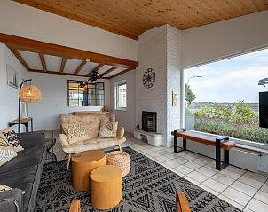 Gezellige woonkamer in vakantiehuis Ostrea 33, Roompot Beach Resort, Kamperland, met uitzicht op de natuur van Noord-Beveland, Zeeland.