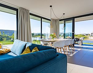 Lichte woonkamer in Waterlijn 03 | De Groote Duynen, vakantiehuis in Kamperland, Noord-Beveland, Zeeland met uitzicht op tuin.