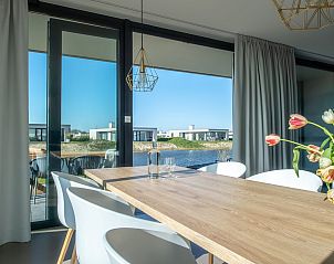 Eetkamer in Waterlijn 03 | De Groote Duynen, vakantiehuis in Kamperland, Noord-Beveland, met uitzicht op het meer.