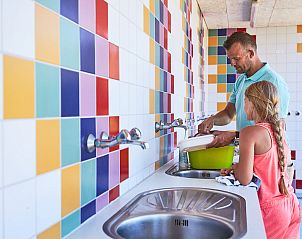 Gemtlicher Waschraum auf dem Wohnmobilstellplatz von RCN de Schotsman in Kamperland, Noord-Beveland, mit farbenfrohen Fliesen und praktischen Einrichtungen.