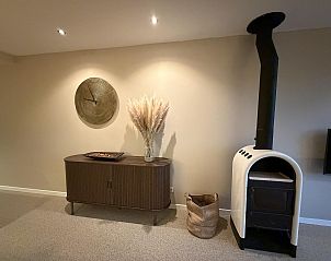 Gezellige woonkamer van Havenweg 24 in Kamperland, Noord-Beveland, Zeeland met stijlvolle houtkachel en moderne inrichting.