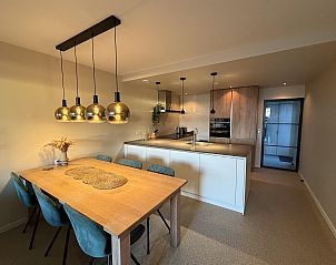 Moderne keuken en eetruimte in Havenweg 24, een vakantiehuis in Kamperland, Noord-Beveland, Zeeland met stijlvolle lampen en houten tafel.