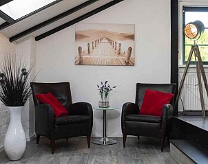 Gezellige zithoek in vakantiehuis ZE947, Kamperland, Noord-Beveland, met comfortabele stoelen en sfeervolle decoratie.