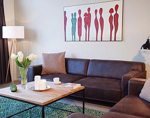 Gemtliches Wohnzimmer des Ferienhauses VZ1178 in Kamperland, mit bequemem Sofa und Kunst an der Wand.