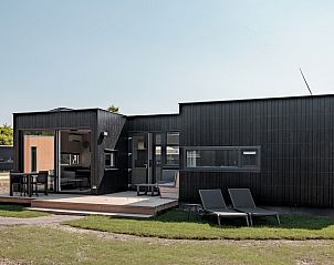 Sauna Lodge 2 in Kamperland, North Beveland offers a modern vacation home experience with a spacious terrace and comfortable lounge chairs.