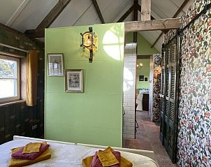Interior of VZ962 Holiday home in Kamperland, with green walls and wooden beams in North Beveland, Zeeland.