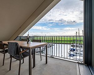 Ruim balkon van VZ2301 Luxe appartement in Kamperland, Noord-Beveland met uitzicht op groene velden.