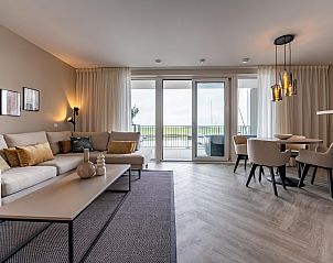 Open woon- en eetruimte in VZ2301 Luxe appartement in Kamperland, Noord-Beveland met grote ramen.