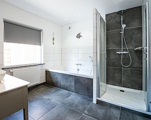 Moderne badkamer met douche en bad in VZ1164 Grote vrijstaande villa in Kamperland.