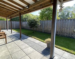 Covered veranda of VZ339 Vakantiewoning Kamperland offers shady relaxation in Zeeland.