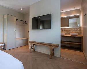 Schlafzimmer mit TV und eigenem Bad im Penthouse Veerweg 173, Kamperland, Port Elisabeth, Zeeland.