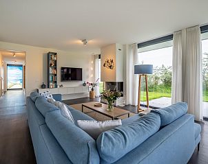 Stilvolles Wohnzimmer in Duinvallei 09, Ferienhaus in Kamperland, Noord-Beveland, mit moderner Einrichtung und Gartenblick.