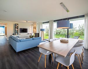 Esszimmer in Duinvallei 09, Ferienhaus in Kamperland, Zeeland, mit groem Tisch und Blick auf die grne Umgebung.