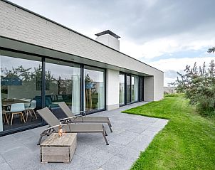 Gerumige Terrasse des Ferienhauses Duinvallei 09 in Kamperland, Noord-Beveland, mit Liegesthlen und grner Umgebung.
