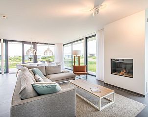 Comfortabele zithoek met open haard in Zandbank 22, vakantiehuis in Kamperland, Zeeland.