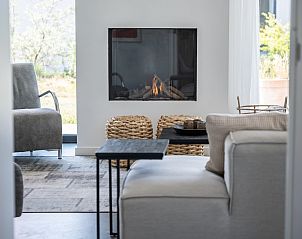 Sfeervolle open haard in Zandbank 21 | De Groote Duynen, Kamperland, met comfortabele stoelen.