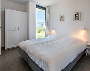 Slaapkamer met tweepersoonsbed in Zandbank 21 | De Groote Duynen, Kamperland, met uitzicht op de tuin.