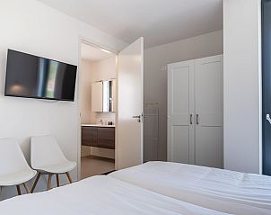 Slaapkamer met tv en ensuite badkamer in Zandbank 21 | De Groote Duynen, Kamperland, Zeeland.