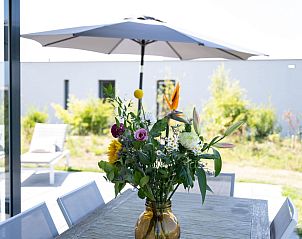 Overdekt terras met eettafel in Zandbank 21 | De Groote Duynen, Kamperland, omgeven door groen.