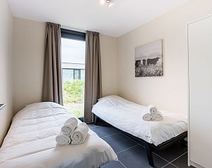 Grote eettafel op het terras van Zandbank 18 | De Groote Duynen, Kamperland, met uitzicht op natuur.