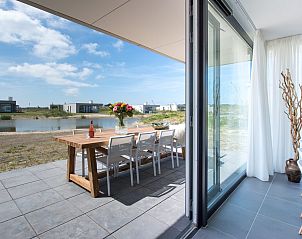 Geniet van een ontspannen terras bij Zandbank 14, De Groote Duynen in Kamperland, met uitzicht op het serene water.