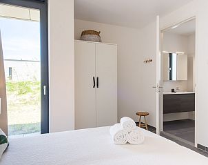 Slaapkamer in Zandbank 14, De Groote Duynen, Kamperland, met comfortabele bedden en toegang tot badkamer.