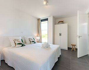 Lichte slaapkamer in Zandbank 14, De Groote Duynen, Kamperland, met moderne meubels en uitzicht op de tuin.