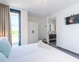 Ruime slaapkamer in Zandbank 14, De Groote Duynen, Kamperland, met flatscreen tv en eigen badkamer.