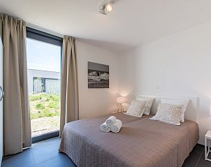 Gastenslaapkamer in Zandbank 14, De Groote Duynen, Kamperland, met tweepersoonsbed en natuurlijke lichtinval.