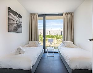 Tweede slaapkamer in Zandbank 14, De Groote Duynen, Kamperland, met twee eenpersoonsbedden en tuinzicht.