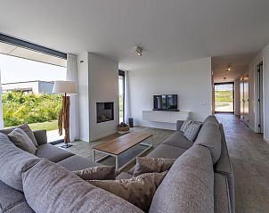 Eetruimte met grote ramen in Duinvallei 08, vakantiehuis in Kamperland, Noord-Beveland, met uitzicht op de natuur.