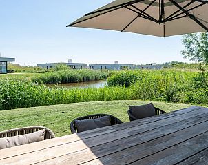 Terras met tuinmeubilair in Duinvallei 08, vakantiehuis in Kamperland, Noord-Beveland, met uitzicht op de natuur.
