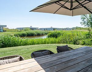 Buitenterras met parasol in Duinvallei 08, een vakantiehuis in Kamperland, Noord-Beveland, Zeeland.