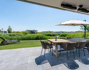 Gezellige woonkamer met uitzicht op de tuin in Duinvallei 08, vakantiehuis in Kamperland, Noord-Beveland, Zeeland.