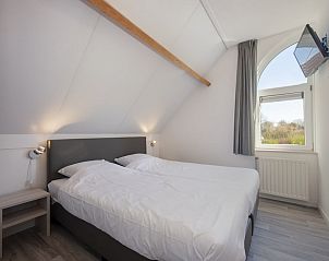 Bright and spacious bedroom in Villa R6A, a vacation home in Kamperland, North Beveland, Zeeland, overlooking the green surroundings.