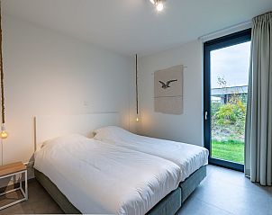 Comfortabele slaapkamer met kunstwerk in Waterlijn 09, vakantiehuis in Kamperland, Zeeland.