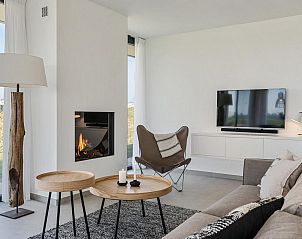 Gezellige woonkamer met open haard in Waterlijn 10, vakantiehuis in Kamperland, Zeeland.