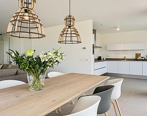 Moderne keuken met houten eettafel in Waterlijn 10, bungalow in Kamperland, Zeeland.